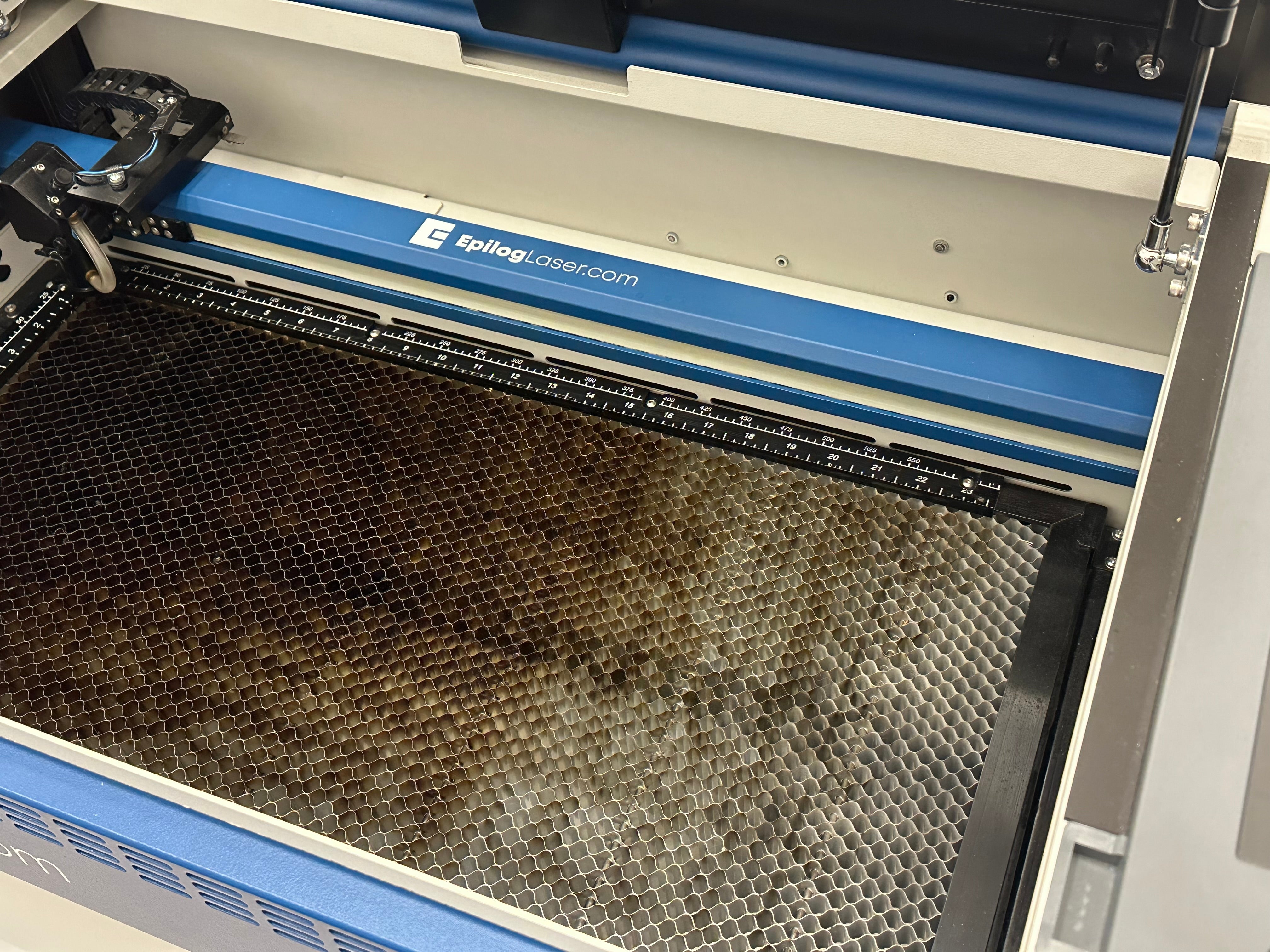 Geöffnete Epilog Fusion Edge 12 Maschine in Blau und Weiß mit Schneidtisch.