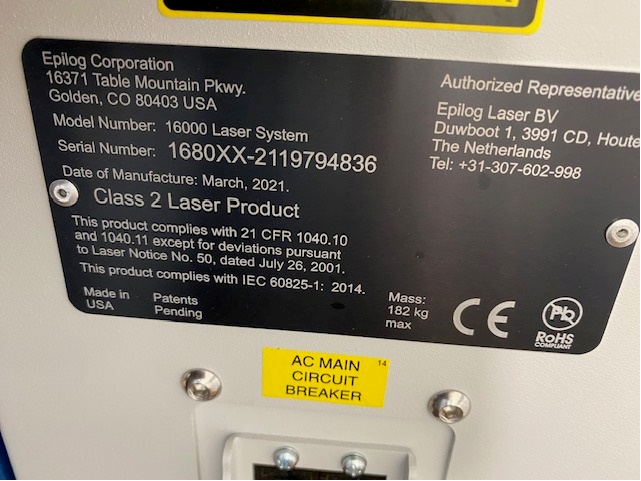 Abgerundetes, Schwarzes Maschineninformationsschild mit Herstellerinformationen, Modellnummer, Seriennummer, Herstellungsnummer, Maschinenbeschreibung, Herstellungsland und Repräsentantenbeschreibung.