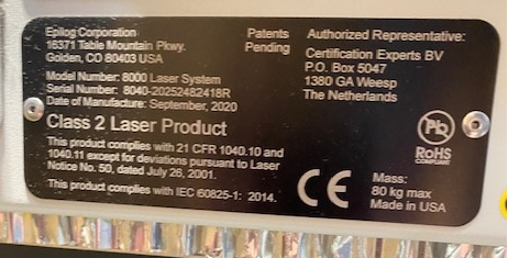 Abgerundetes, Schwarzes Maschineninformationsschild mit Herstellerinformationen, Modellnummer, Seriennummer, Herstellungsdatum, Maschinenbeschreibung, Herstellungsland und Repräsentantenbeschreibung.