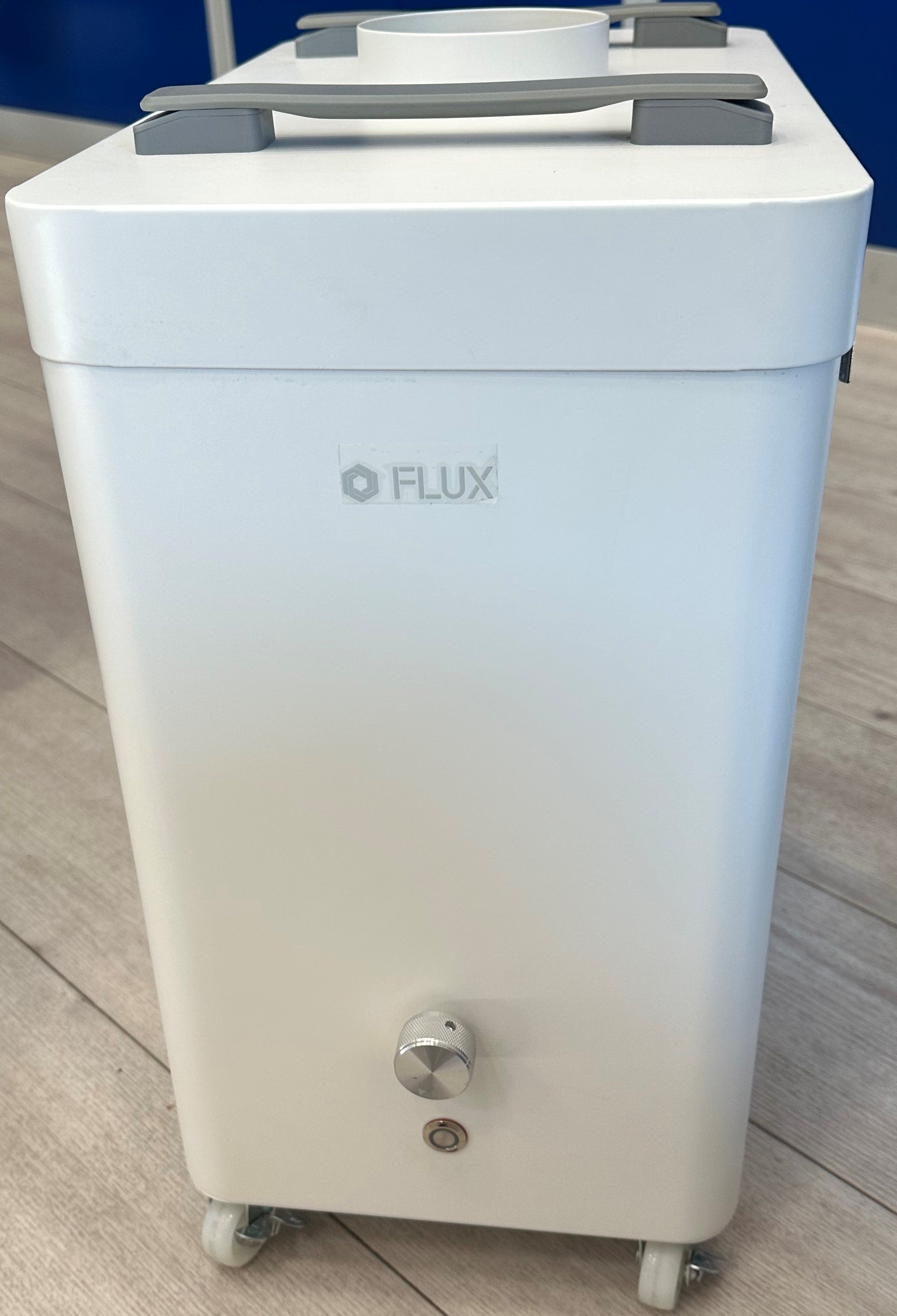 FLUX Beam Air Absauganlage in Weiß mit Rollen am Boden und Träger an der Decke.