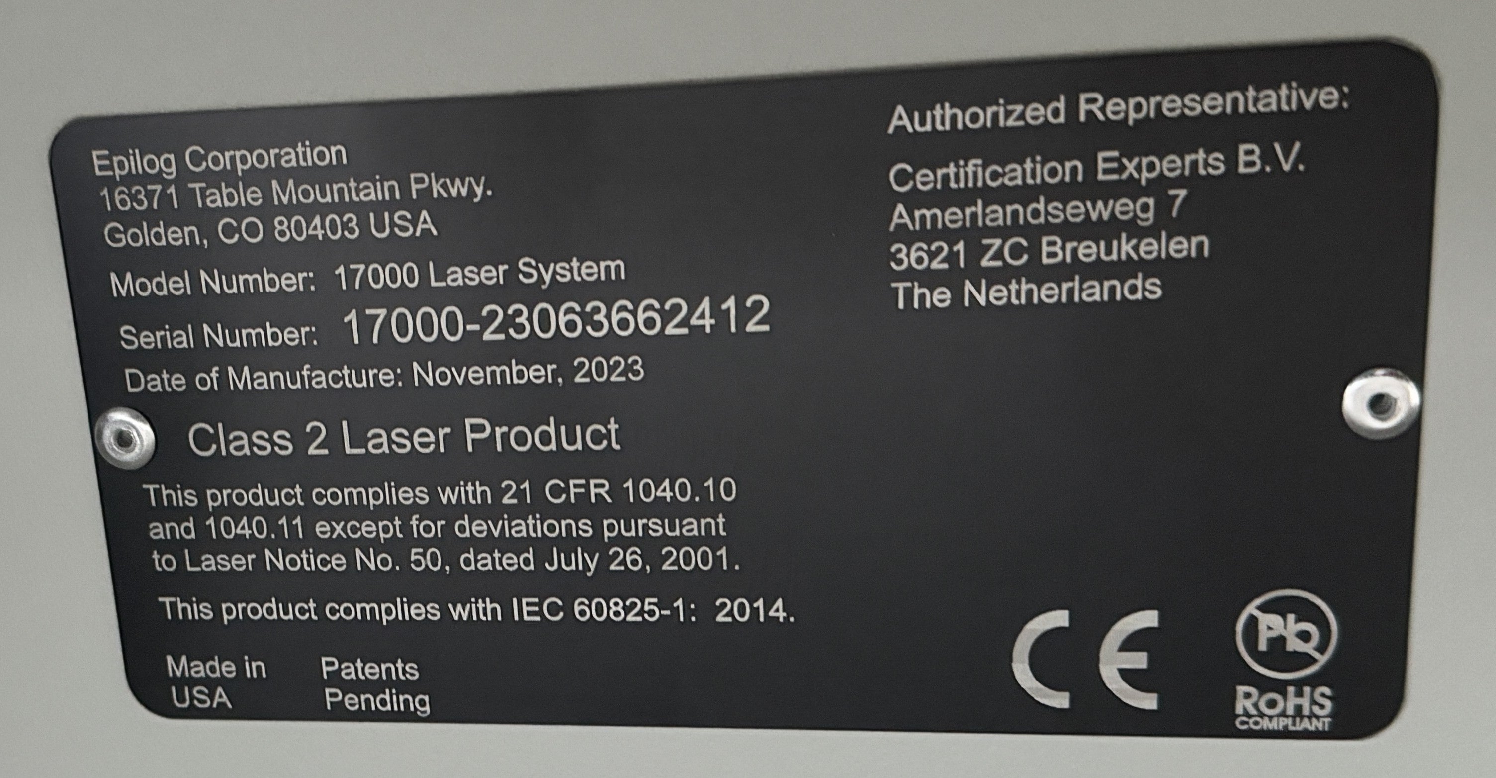 Abgerundetes, Schwarzes Maschineninformationsschild mit Herstellerinformationen, Modellnummer, Seriennummer, Herstellungsdatum, Maschinenbeschreibung, Herstellungsland und Repräsentantenbeschreibung.