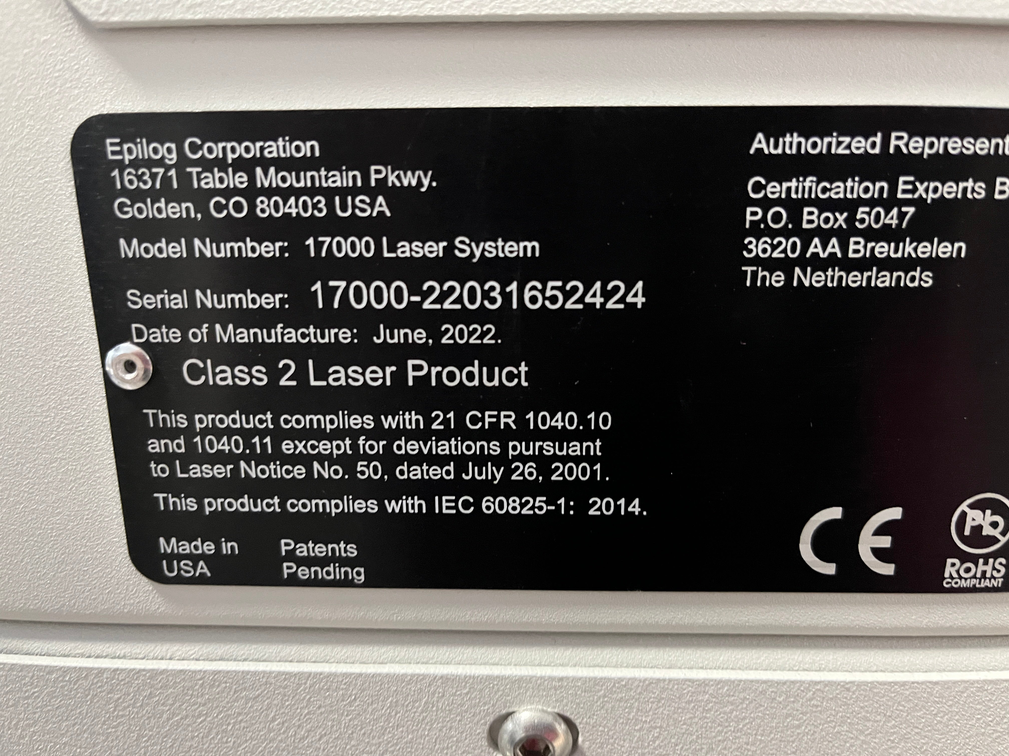 Schwarzes, Abgerundetes Maschineninformationsschild mit Herstellerinformationen, Modellnummer, Seriennummer, Herstellungsdatum, Maschinenbeschreibung, Herstellungsland und Repräsentantenbeschreibung.