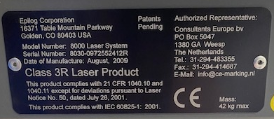 Schwarzes, Abgerundetes Maschineninformationsschild mit Herstellerinformationen, Modellnummer, Seriennummer, Herstellungsdatum, Maschinenbeschreibung und Repräsentantenbeschreibung.