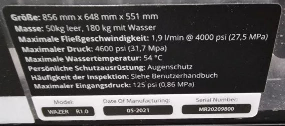 Schwarzes Schild mit Maschineninformationen auf der Rückseite der Maschine mit  Größe, Masse, max. Fließgeschwindigkeit, max. Druck, max. Wassertemperatur, Persönliche Schutzausrüstung, Häufigkeit der Inspektion und max. Eingangsdruck.