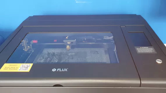 Flux Beambox Maschine in Schwarz mit Schneidbrett, Glashaube und Touchscreen.